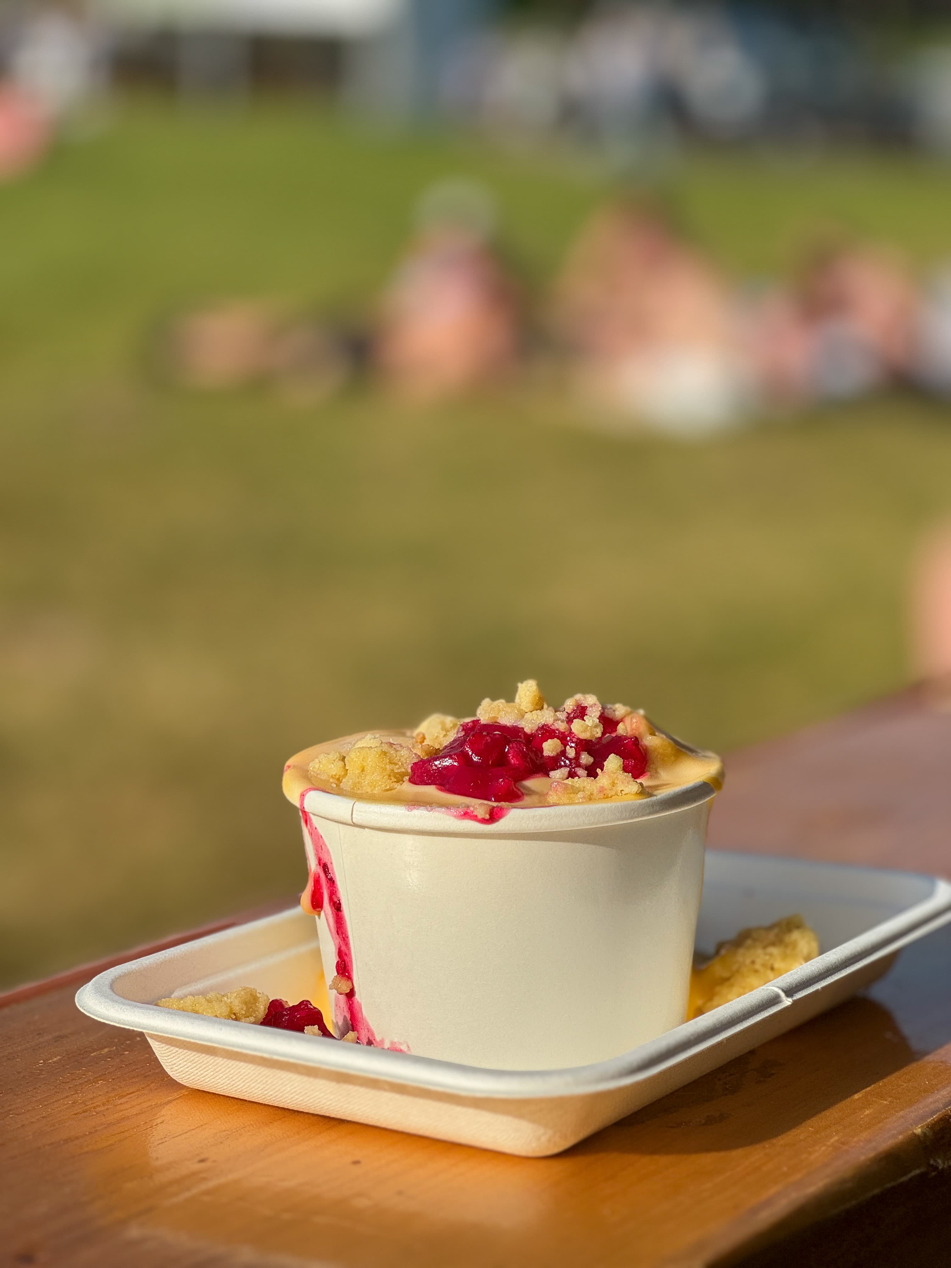 Apple & raspberry crumble with custard at a food festival