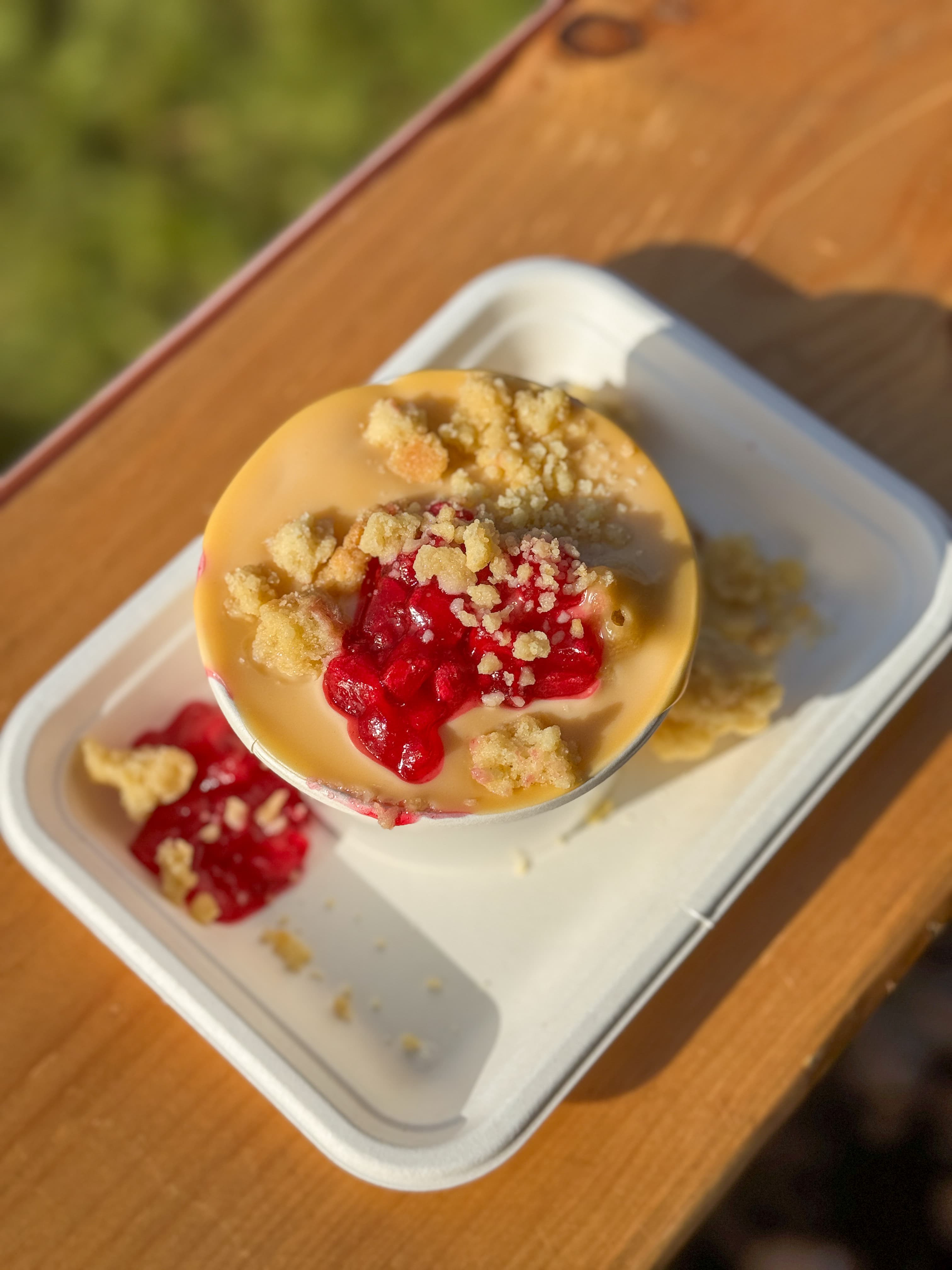 Overhead shot of crumble and custard with raspberry compote